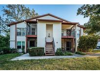 Two-story condo building with balconies and landscaping at 3455 Countryside Blvd # 52, Clearwater, FL 33761