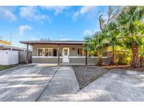 Charming home with large driveway and mature landscaping, including palm trees at 1786 Nevada Ne Ave, St Petersburg, FL 33703