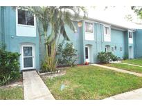 Light blue townhome exterior with grassy yard at 117 114Th N Ave # 117, St Petersburg, FL 33716