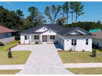 Modern two-story home with a large driveway and landscaped yard at 4716 Hickory Oak Dr, Brooksville, FL 34601