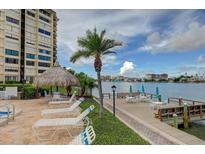 Beautiful waterfront pool deck and lounge area with tikihut and expansive views at 700 Island Way # 106, Clearwater Beach, FL 33767
