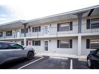 Exterior view of a light-grey building with parking in front at 101 Lake Ne Ave # 211, Largo, FL 33771