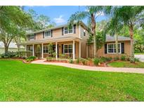 Two-story house with a large front porch and landscaped yard at 27929 Lincoln Pl, Wesley Chapel, FL 33544