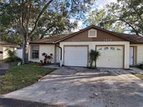Front view of a twin home with a driveway and landscaping at 2672 Arjay Ct, Palm Harbor, FL 34684