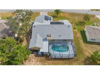 Aerial view of house, pool, and solar panels at 14070 Amero Ln, Spring Hill, FL 34609