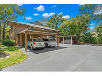 Multi-vehicle carport with ample parking space and lush landscaping surrounds this well-maintained home at 104 Cypress Pond Rd, Palm Harbor, FL 34683