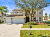 Two-story house with three-car garage and well-manicured lawn at 17800 Souter Ln, Land O Lakes, FL 34638