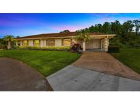 Charming single story home with a well maintained lawn, mature landscaping, and a two-car carport at 2104 Hembury Pl # 33, Sun City Center, FL 33573