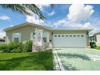 Single story home with a large garage and a landscaped yard at 37449 Gill Ave, Zephyrhills, FL 33541