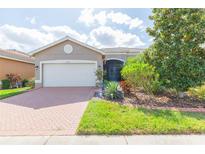 One-story home with a brick driveway, two-car garage, and nicely landscaped yard at 4941 Marble Springs Cir, Wimauma, FL 33598