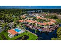 An aerial view of a waterfront condominium complex with a pool and boat docks at 2571 Cyprus Dr # 1-202, Palm Harbor, FL 34684