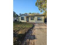 Charming single-story home with a well-maintained lawn and a brick walkway leading to the front door at 3718 E Henry Ave, Tampa, FL 33610