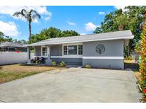 Charming single-story home with a well-manicured lawn, a modern gray exterior, and a welcoming front porch at 5721 12Th S Ave, Gulfport, FL 33707