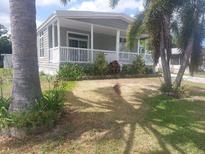 Charming single-story home featuring a quaint porch and well-maintained landscaping, nestled amongst mature palms at 140 Independence Ave # 11, Palm Harbor, FL 34684