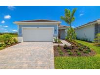 Single-story home with gray siding, white garage door, and landscaped front yard at 17766 Solstice Ave, Venice, FL 34293