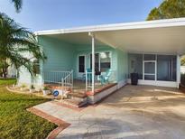 Inviting light teal home exterior with covered porch and landscaped yard at 12501 Ulmerton Rd # 82, Largo, FL 33774