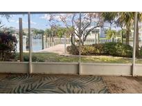 Screened lanai view of backyard leading to a waterfront with private dock in a tropical setting at 1943 Bayou Grande Ne Blvd, St Petersburg, FL 33703