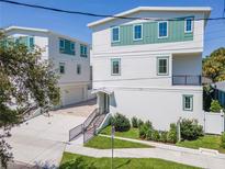 Modern two-story home featuring white siding, green accents, and well-maintained landscaping at 407 S Albany Ave # 6, Tampa, FL 33606