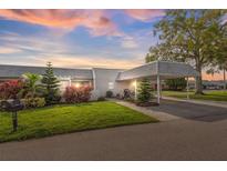 Condo exterior at sunset with carport and landscaping at 3942 Trophy Blvd, New Port Richey, FL 34655