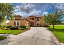 Two-story house with terracotta tile roof, landscaped yard, and a three-car garage at 20103 Shady Hill Ln, Tampa, FL 33647