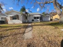 Single-story home with attached garage, mature trees, and a walkway at 469 80Th Way, St Pete Beach, FL 33706