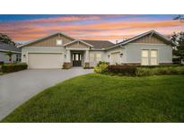 Home exterior at dusk with a two-car garage and manicured lawn at 101 Brookover Ln, Brandon, FL 33511
