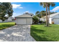 One-story house with attached garage and landscaped yard at 11036 Via De Rosa Ln, Spring Hill, FL 34608