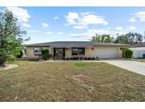 Single story home with attached garage and well-maintained lawn at 1706 Flamingo Ln, Sun City Center, FL 33573