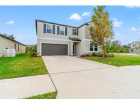 Two-story house with gray exterior and a dark garage door at 1911 Fan Aloe Way, Ruskin, FL 33570