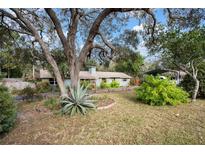 Ranch house with a long driveway and mature landscaping at 9927 Osceola Dr, Weeki Wachee, FL 34613