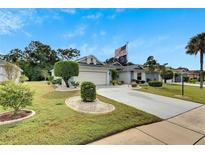 Single-story house with manicured lawn and American flag at 2113 E Del Webb Blvd, Sun City Center, FL 33573