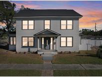 Two-story house with gray siding, dark trim, and a well-lit entrance at 500 53Rd S St, St Petersburg, FL 33707