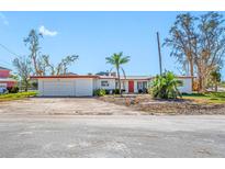 White single story home with red trim, attached garage, and large lot at 5412 Pali Way, St Pete Beach, FL 33706