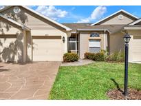 Beige exterior with a two-car garage and landscaping at 2403 Nantucket Green Ct # 0, Sun City Center, FL 33573