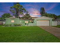 Charming light green house with a two-car garage and landscaped yard at 3887 50Th S Ave, St Petersburg, FL 33711