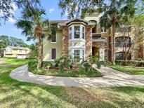 Attractive condominium exterior with stone accents, bay window, and mature landscaping with palm trees at 10108 Courtney Oaks Cir # 203, Tampa, FL 33619