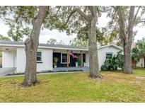 Charming ranch home with a white exterior, green door, and mature trees at 4110 W Euclid Ave, Tampa, FL 33629