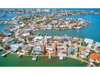 Aerial view of waterfront home with private dock and lush landscaping at 475 Harbor N Dr, Indian Rocks Beach, FL 33785