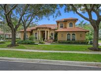 Two-story house with tile roof and landscaping at 531 Isleworth Close, Tarpon Springs, FL 34688