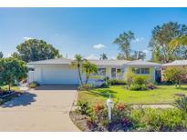 Ranch style home with white garage door and yellow accents at 2043 Imperial Way, Clearwater, FL 33764