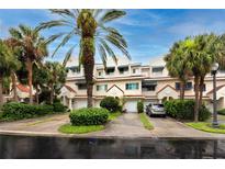 Front view of charming townhouses with lush landscaping and palm trees at 4630 Mirabella Ct, St Pete Beach, FL 33706
