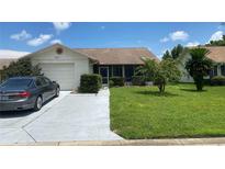 House exterior, featuring a garage and well-maintained lawn at 8101 Casuarina Dr, Port Richey, FL 34668