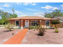 Attractive single-story home with a brick-paved driveway, a white door, and well-kept front yard landscaping at 460 48Th S St, St Petersburg, FL 33711