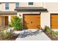 Two-car garage with tan doors and walkway at 5315 Companion Ln, Tampa, FL 33619