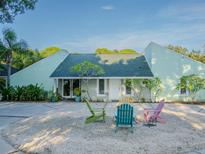 Light teal house with gravel courtyard and fire pit at 8900 143Rd St, Seminole, FL 33776