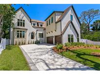 Beautiful two-story home showcasing a brick driveway and lush green lawn at 4633 W Lowell Ave, Tampa, FL 33629