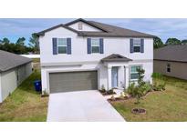 Two-story house with gray siding, landscaping, and a two-car garage at 11711 Lavender Loop, Spring Hill, FL 34609