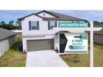 Two-story home with a two-car garage and discounted rate sign at 11711 Lavender Loop, Spring Hill, FL 34609