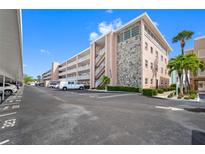 Condo building exterior with parking and landscaping at 6363 Gulf Winds Dr # 437, St Pete Beach, FL 33706