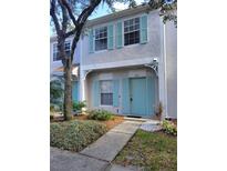 Two-story townhome with teal door and landscaping at 8661 Hunters Key, Tampa, FL 33647